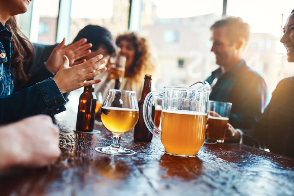 Friends at a table enjoying beer on craft beer tour booked with acx travel.