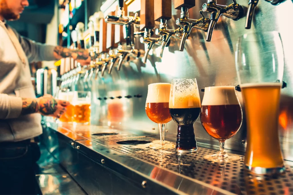 Bartender filling glasses with craft beer on tap.