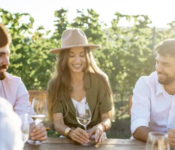Friends at table tasting wine on excursion booked with acx travel.