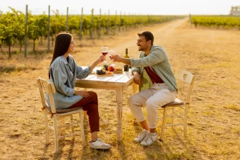 Couple having romantic wine tasting at vineyard.